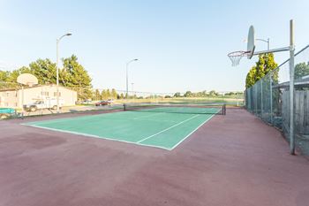 Outdoor area at Castlerock Apartment Homes with 2 tennis courts and a basketball court.